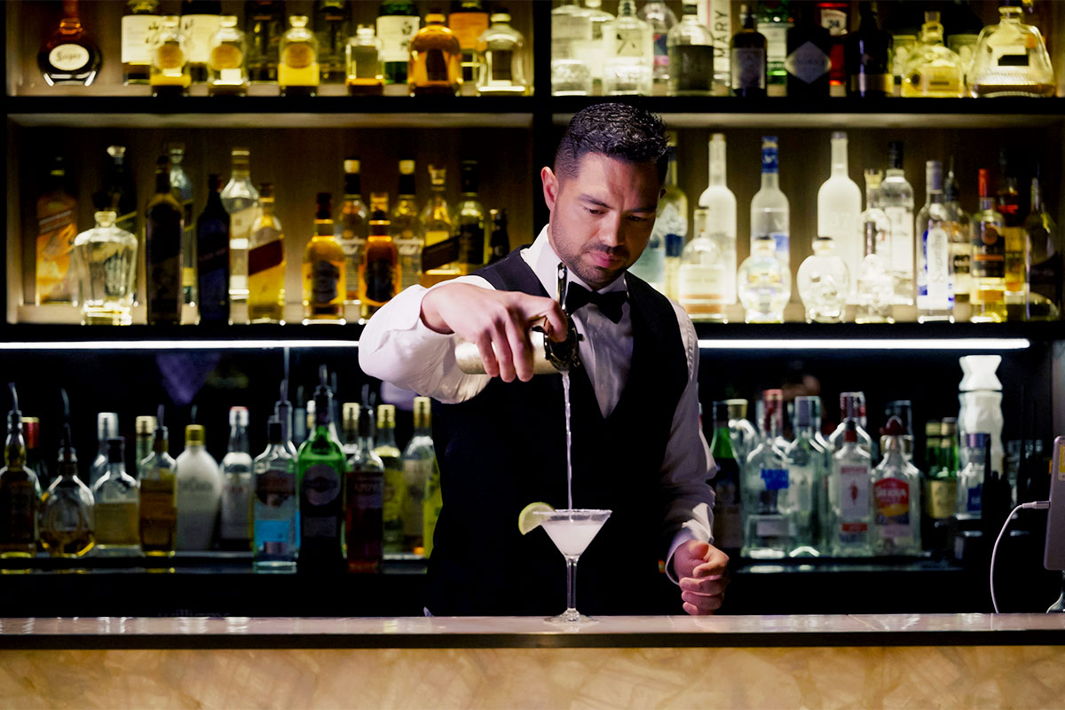 Bar Bina barman pouring cocktail