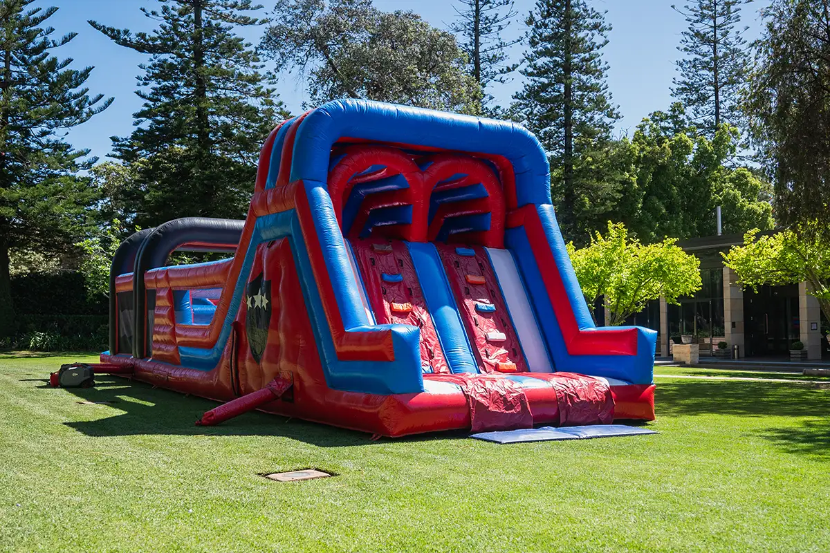 Inflatable obstacle course set up on the lawn at Curzon Hall for a kids' party